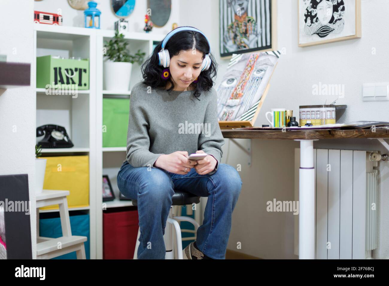Retrato de una joven estudiante de arte usando su teléfono móvil mientras estaba en su estudio. Espacio para texto. Foto de stock
