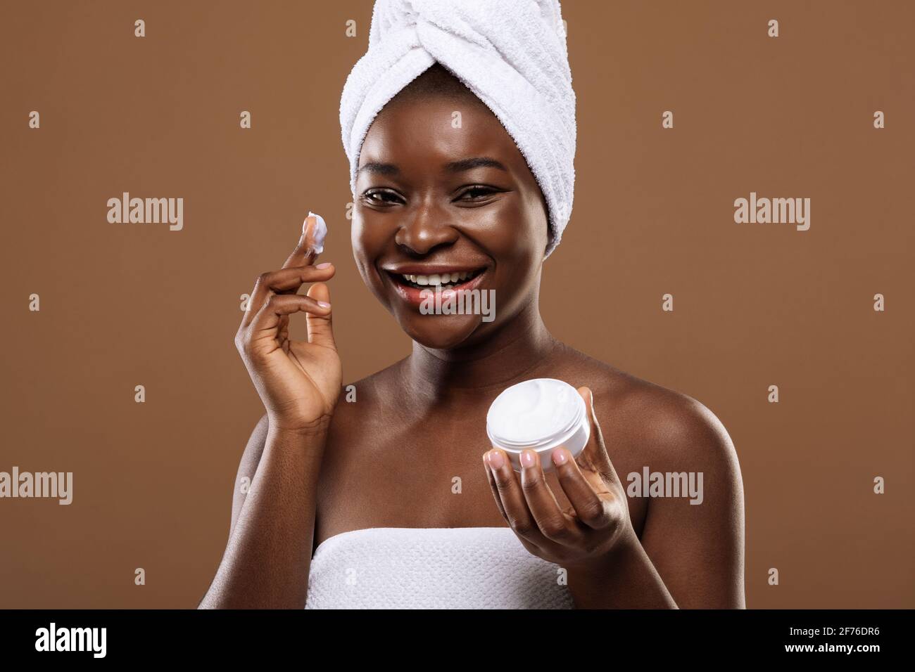 Concepto de cuidado de la piel. Joven dama negra aplicando crema facial  hidratante después de baño Fotografía de stock - Alamy