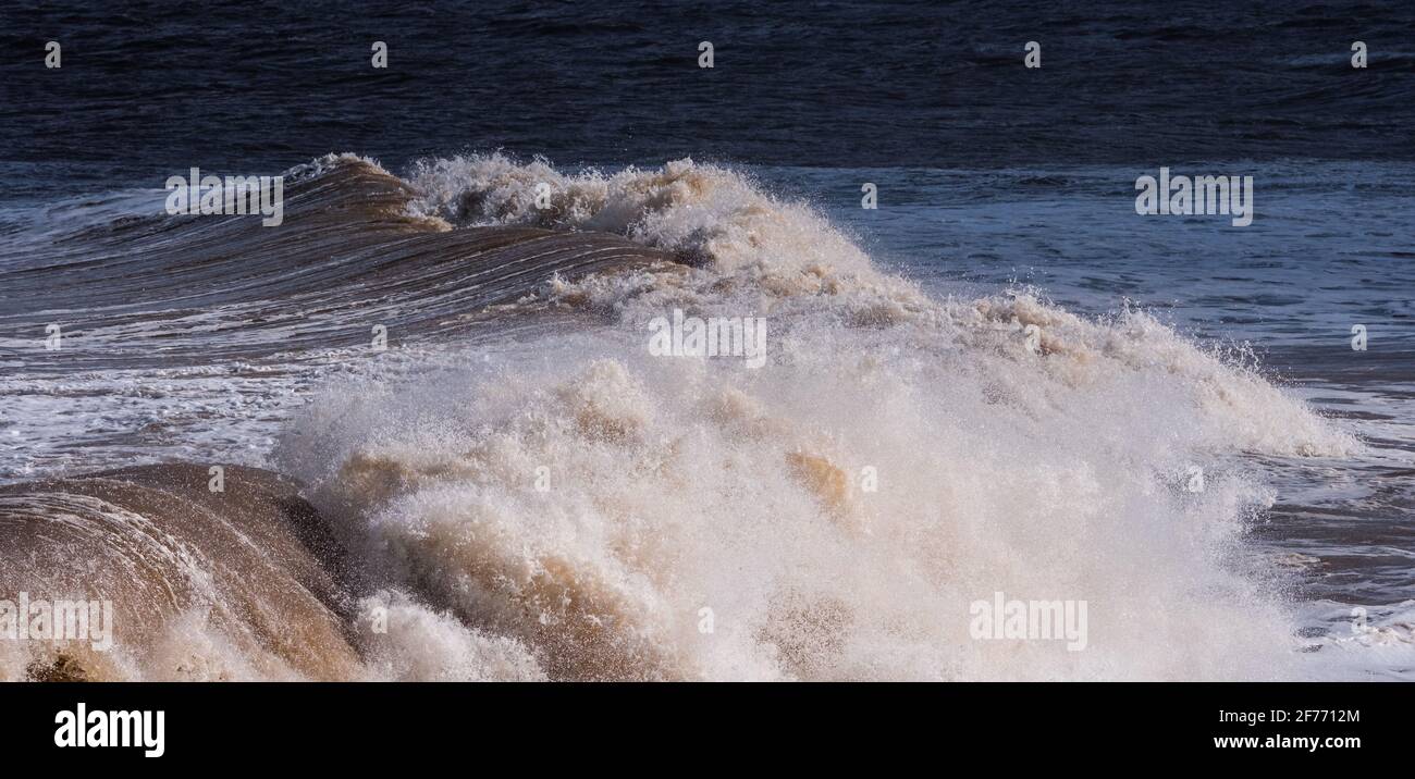 Poderosas olas del Mar del Norte golpeando las playas de La costa de Lincolnshire que muestra la potencia bruta del mar y la vida buscada por la gente de la ciudad Foto de stock
