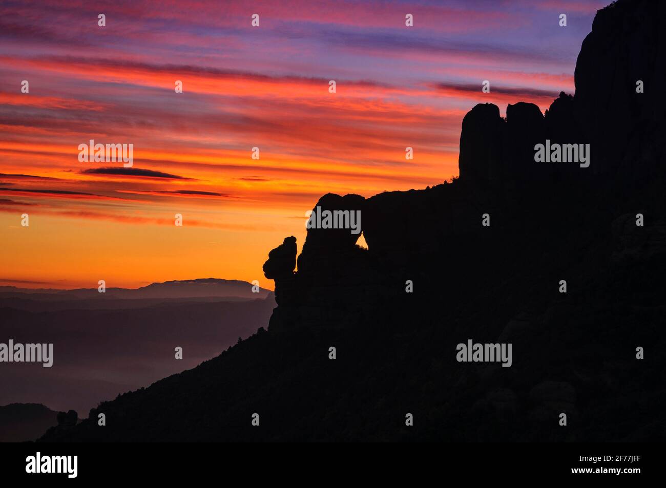 Montserrat cara oeste y Roca Foradada vista desde Sant Pau Vell de la Guàrdia al amanecer con cielo rojo (provincia de Barcelona, Cataluña, España) Foto de stock