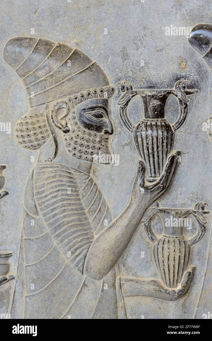 Irán, Persépolis, catalogado como Patrimonio de la Humanidad por la UNESCO, las escaleras del este de Apadana, bajo relieve que representa un afluente armenio que lleva el vino al rey Foto de stock