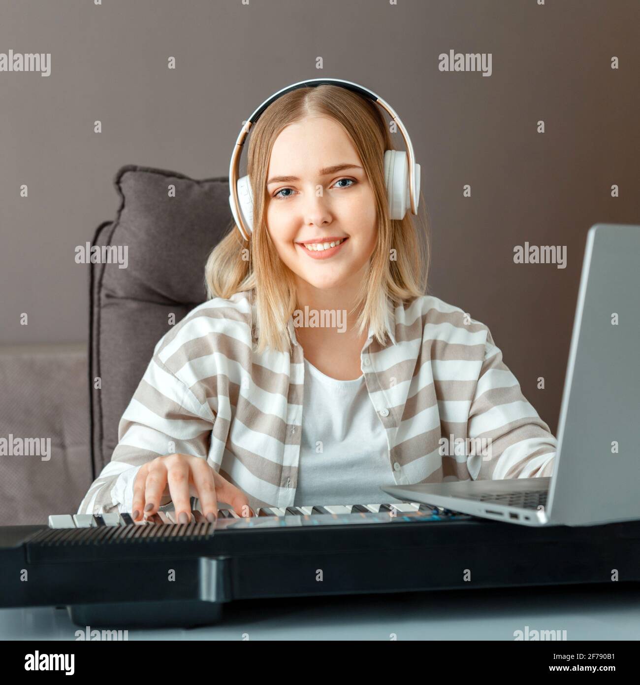Mujer en los auriculares dj grabar música de audio con el portátil.Teenager  chica tocar el sintetizador de piano durante la lección en línea, aprender  a tocar el piano en línea en casa