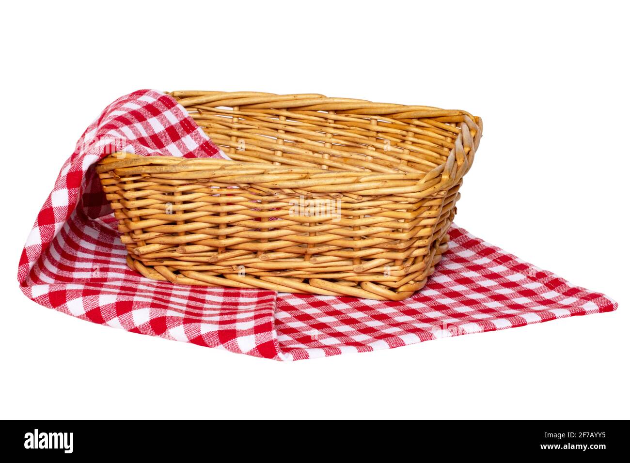 Cesta de picnic vacía. Primer plano de una cesta vacía de mimbre sobre una  servilleta, manta o mantel de cuadros blancos rojos aislados sobre un fondo  blanco. Para su Fotografía de stock -