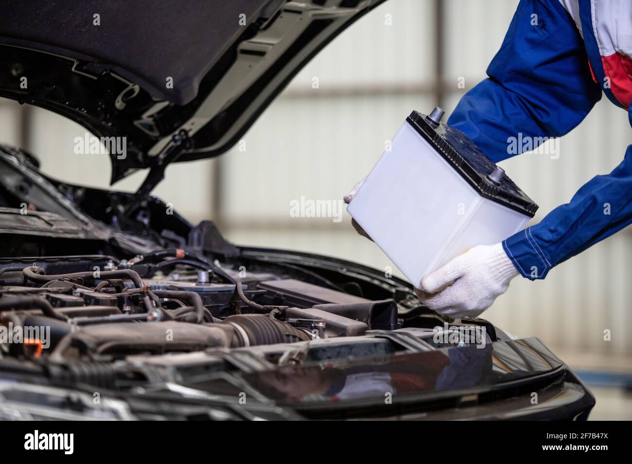 Mano de hombre mecánico cambiando la batería del coche, reparador de la  batería del coche Fotografía de stock - Alamy
