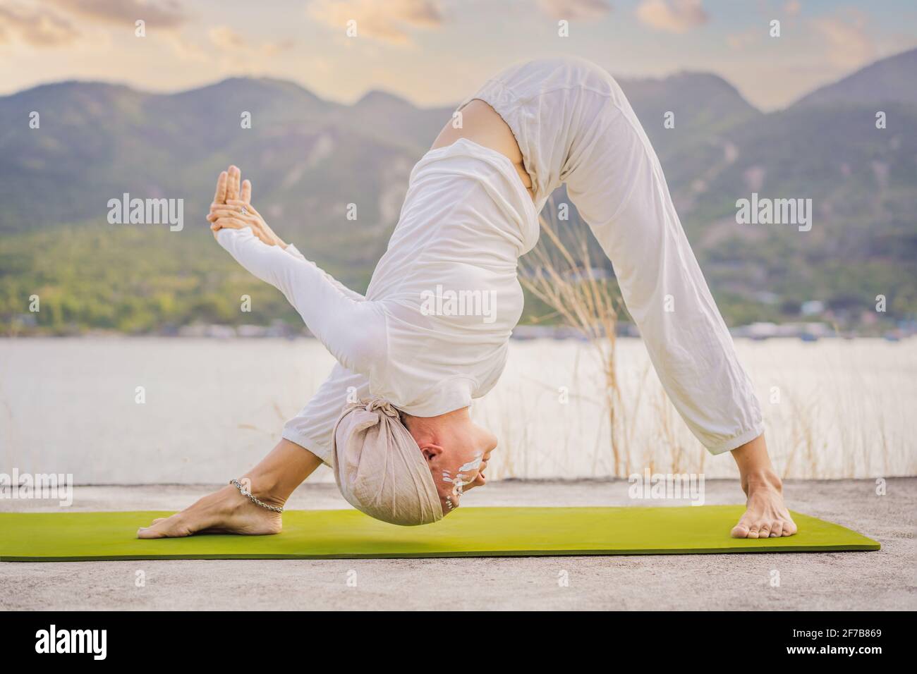 Por adelantado robot Lustre Kundalini yoga mujer con ropa blanca y turbante practica yoga kundalini en  el fondo del mar, las montañas y la puesta de sol. Lucha contra la pintura  de cara Fotografía de stock -
