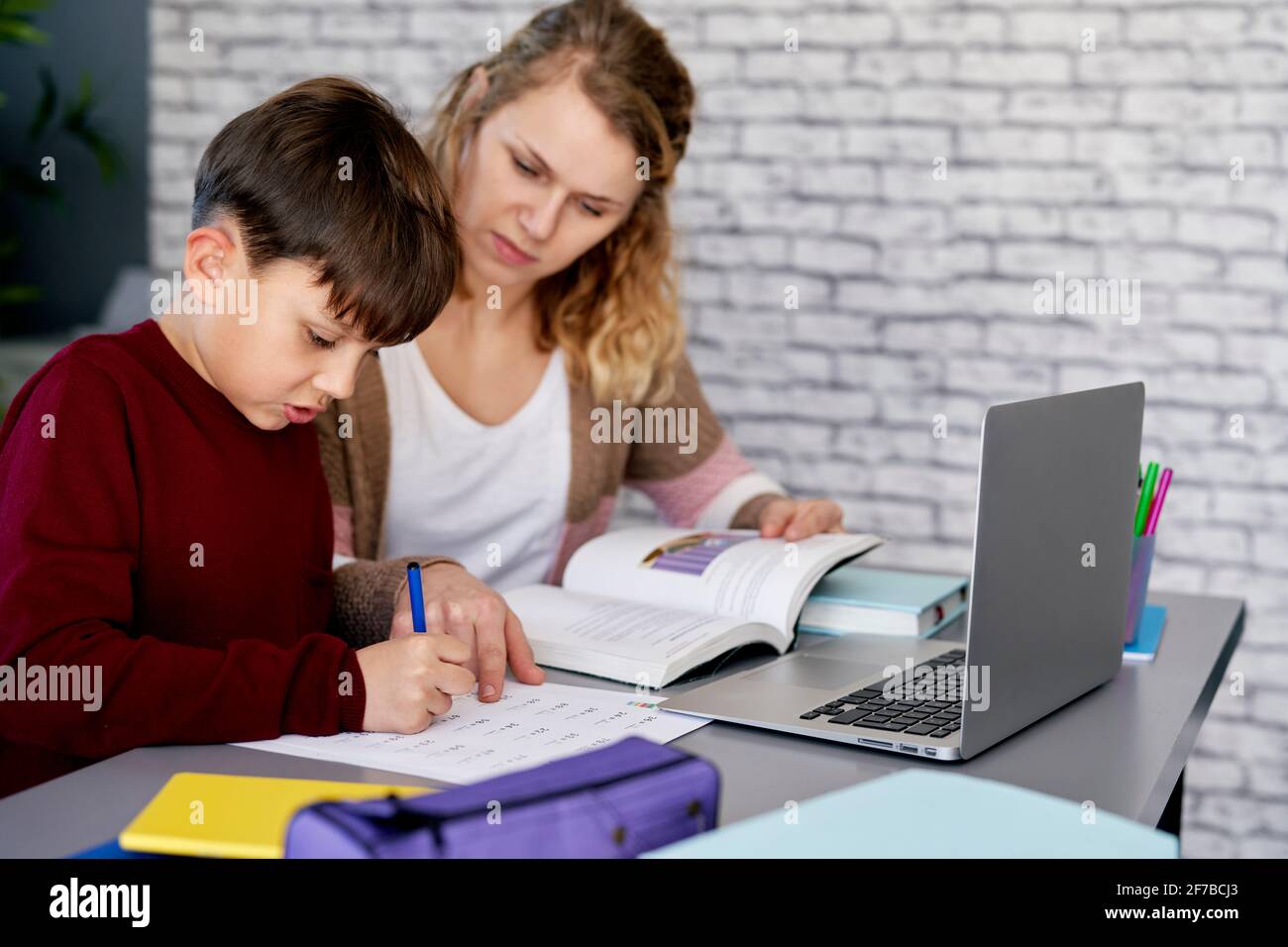 Madre ayudando a su hijo con el trabajo escolar Foto de stock