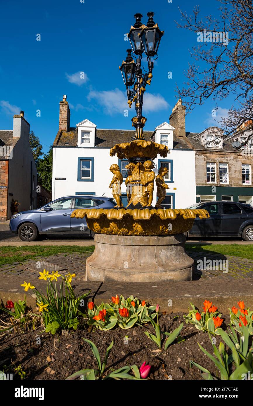 Fuente victoriana restaurada de hierro fundido con tres lámparas y figuras infantiles con jarrones, East Linton, East Lothian, Scotland, UK Foto de stock
