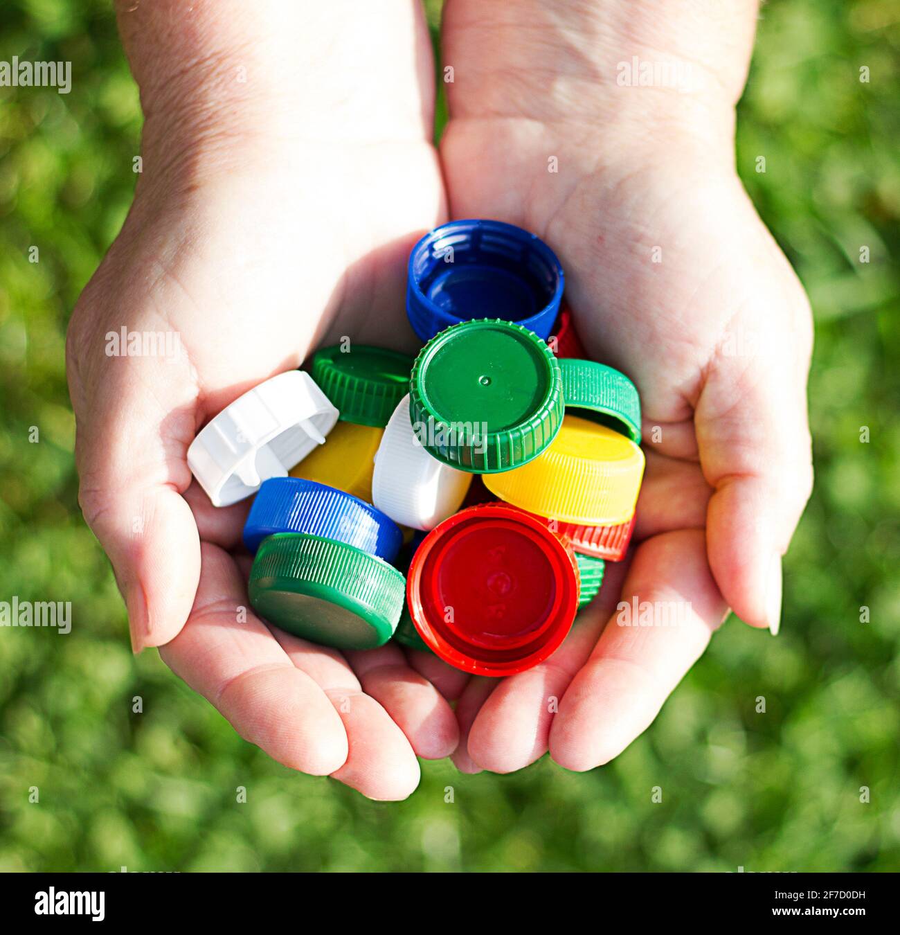 tapones de plástico de colores en las manos de las mujeres. el concepto de  ecología Fotografía de stock - Alamy