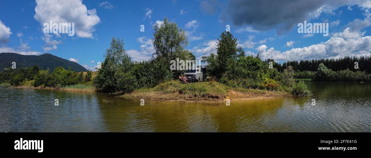 Panorama de Zovnesko jezero o Zovnek lago en Eslovenia, en un caluroso día  de verano. Caravana de aventura aparcada visible en la península de la costa  Fotografía de stock - Alamy