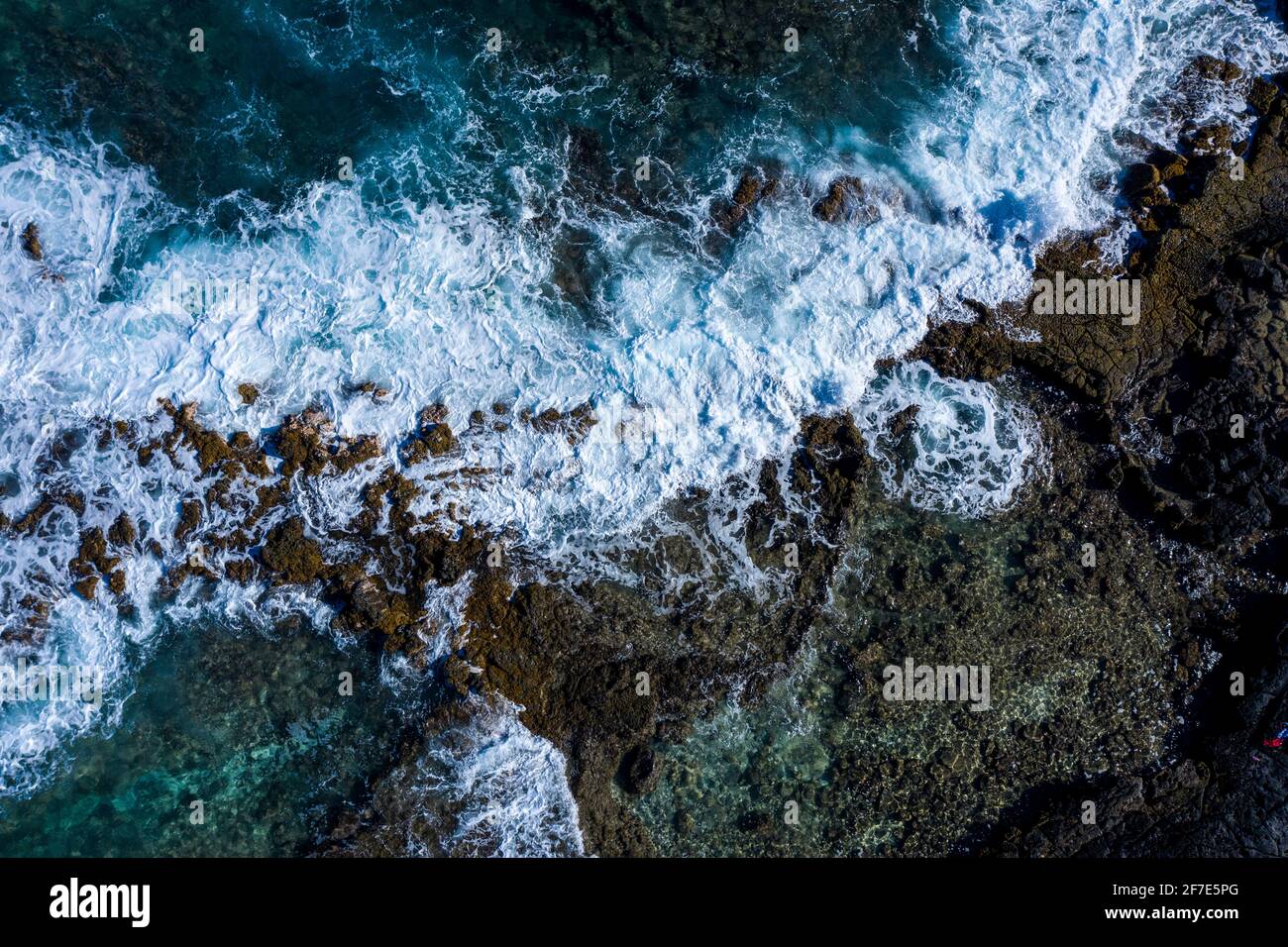 Fuertes aguas blancas golpeando contra las rocas a lo largo del océano en Hawaii Foto de stock