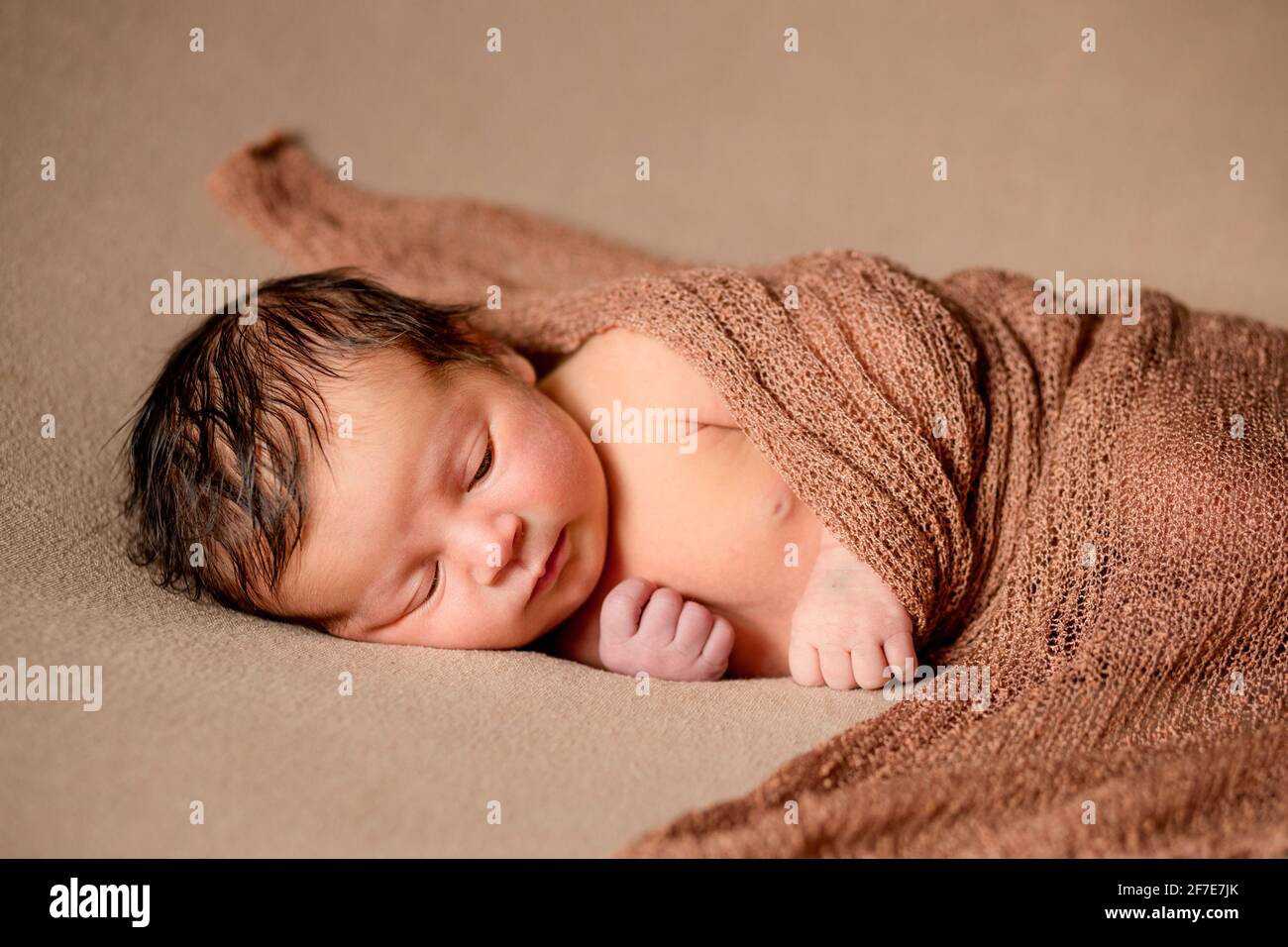 Bebé nacido durmiendo tranquilamente con tela de cuadros sobre fondo de stock - Alamy
