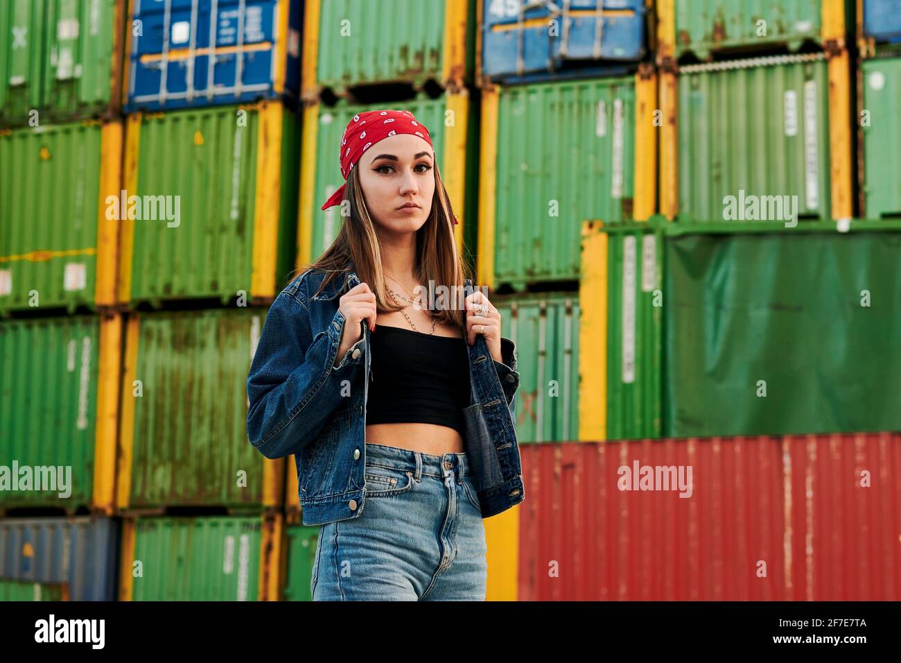 Destruir digestión Mus Mujer joven en ropa urbana poses rodeado de contenedores de transporte  Fotografía de stock - Alamy