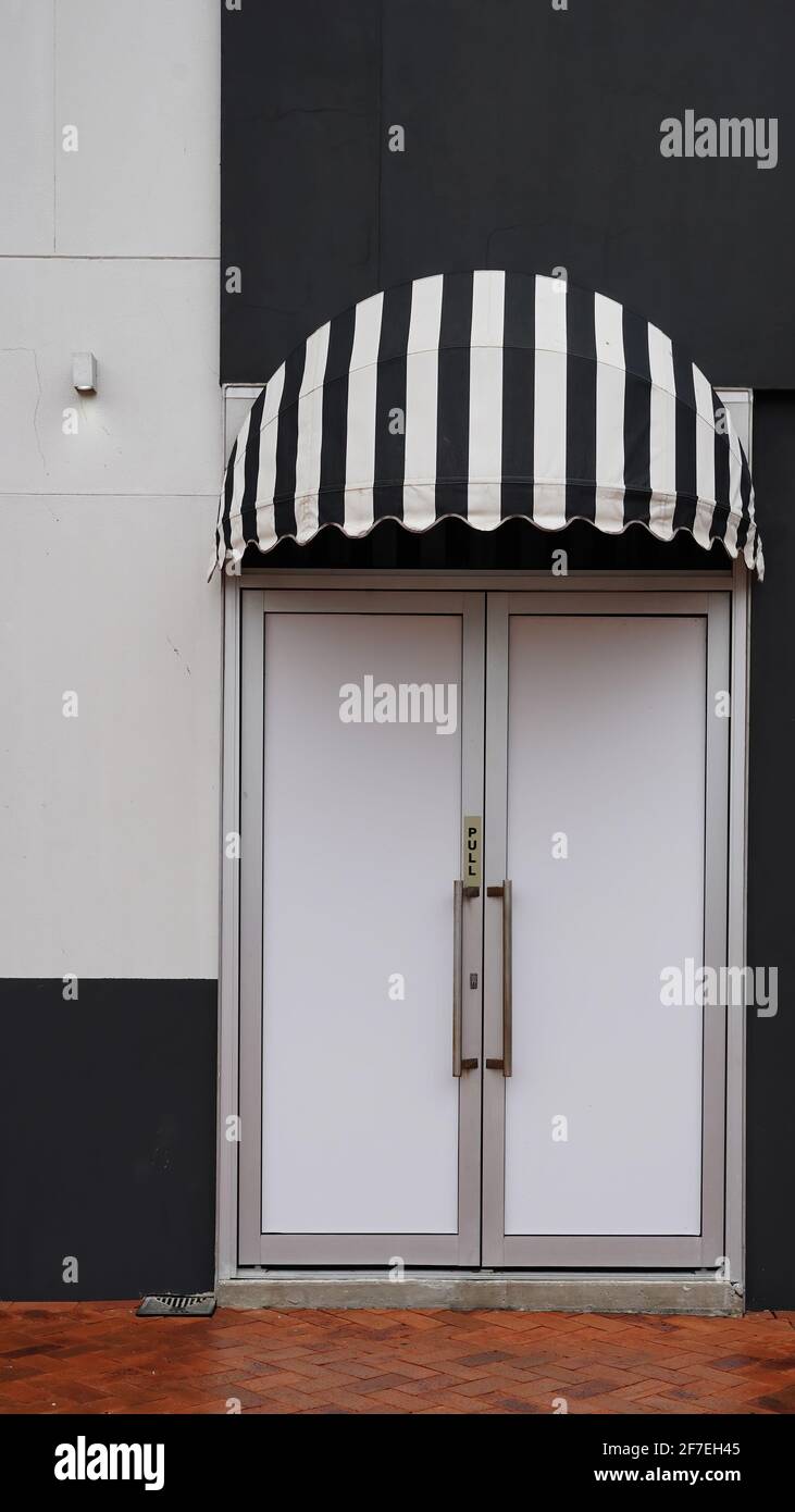 Puerta delantera con toldo de lona a rayas blancas y negras Fotografía de  stock - Alamy