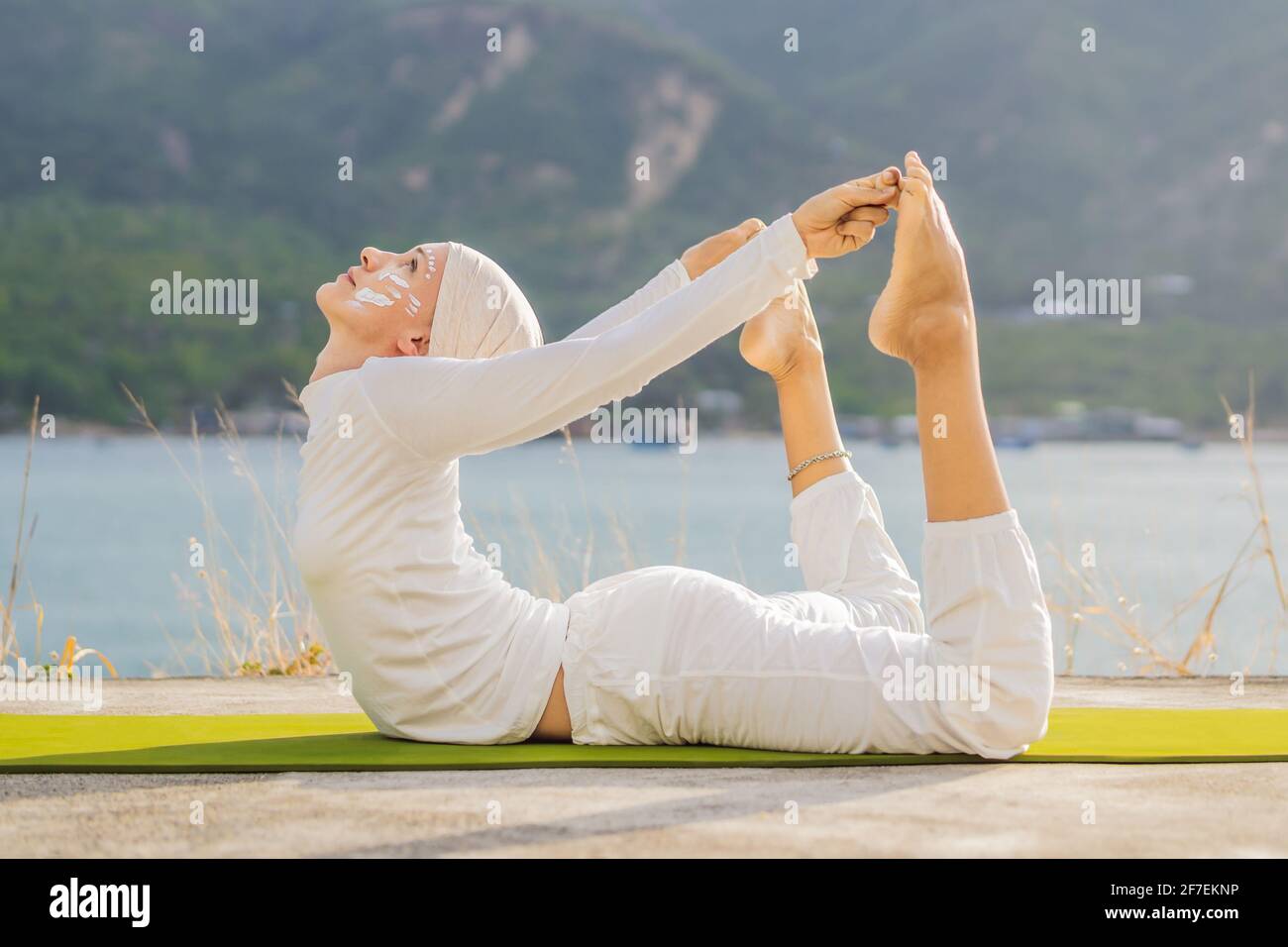 Por adelantado robot Lustre Kundalini yoga mujer con ropa blanca y turbante practica yoga kundalini en  el fondo del mar, las montañas y la puesta de sol. Lucha contra la pintura  de cara Fotografía de stock -