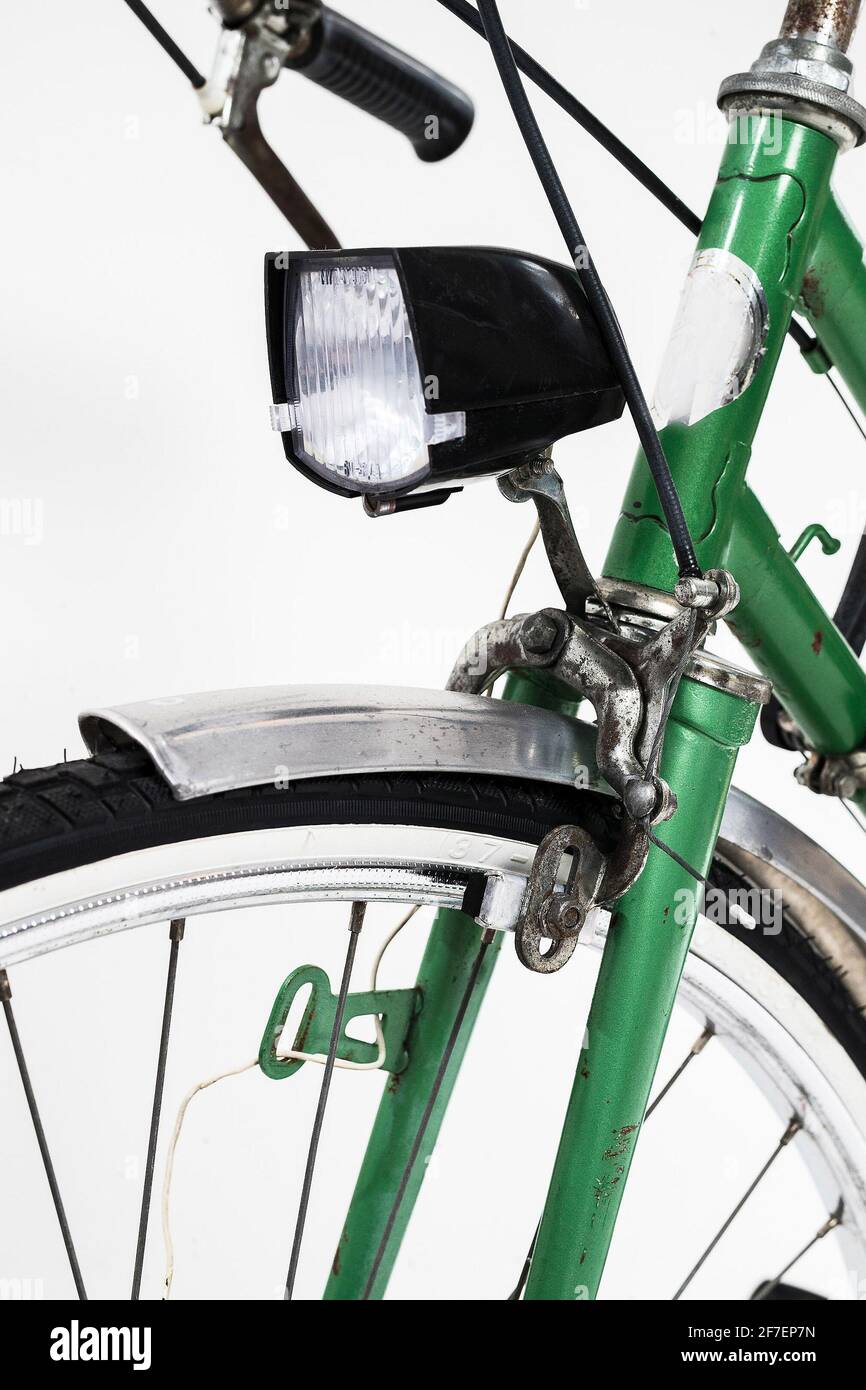 Una antigua ciudad retro de aspecto verde vintage bicicleta para mujeres,  aislado o fondo blanco. Detalle de la luz delantera y del freno delantero  con pastillas de freno Fotografía de stock -