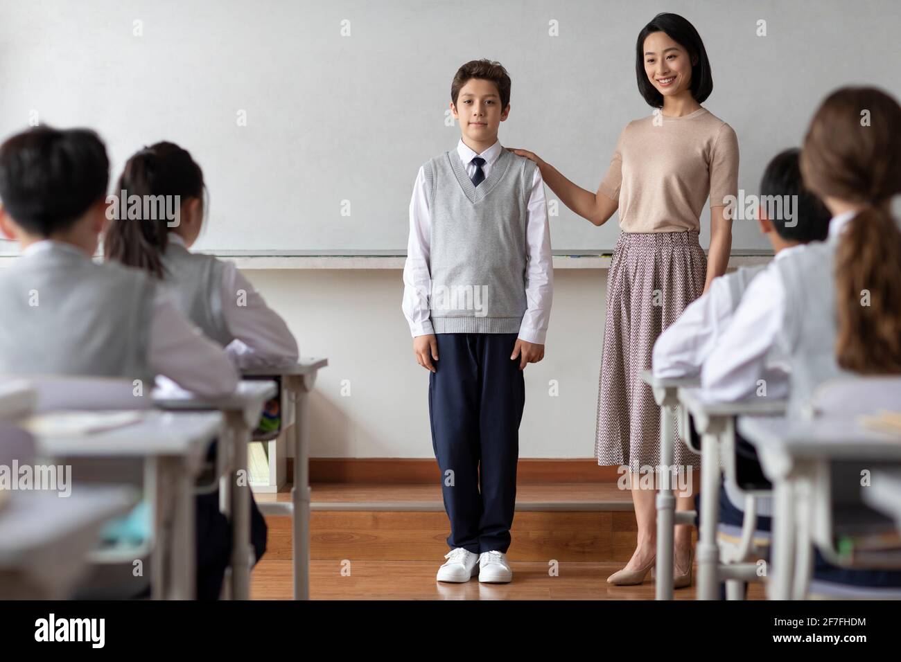 Joven profesor presentando a un nuevo compañero de clase en el aula