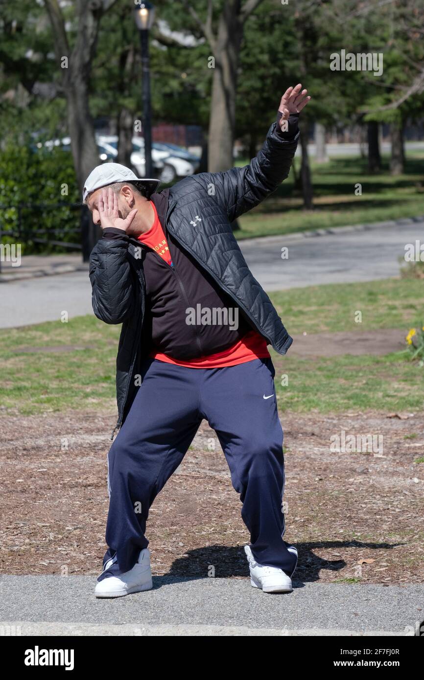Un hombre dirige una clase de Zumba a través de un vigoroso ejercicio de baile en un parque en Queens, Nueva York. Foto de stock