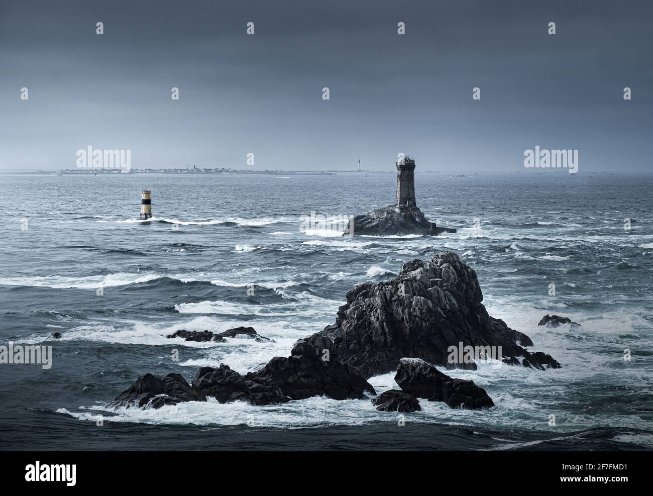 Vista del océano en Pointe du Raz con dos faros, Phare de la Vieille y Tourelle de la Plate (Petite Vieille), en el mar y las rocas, Francia Foto de stock