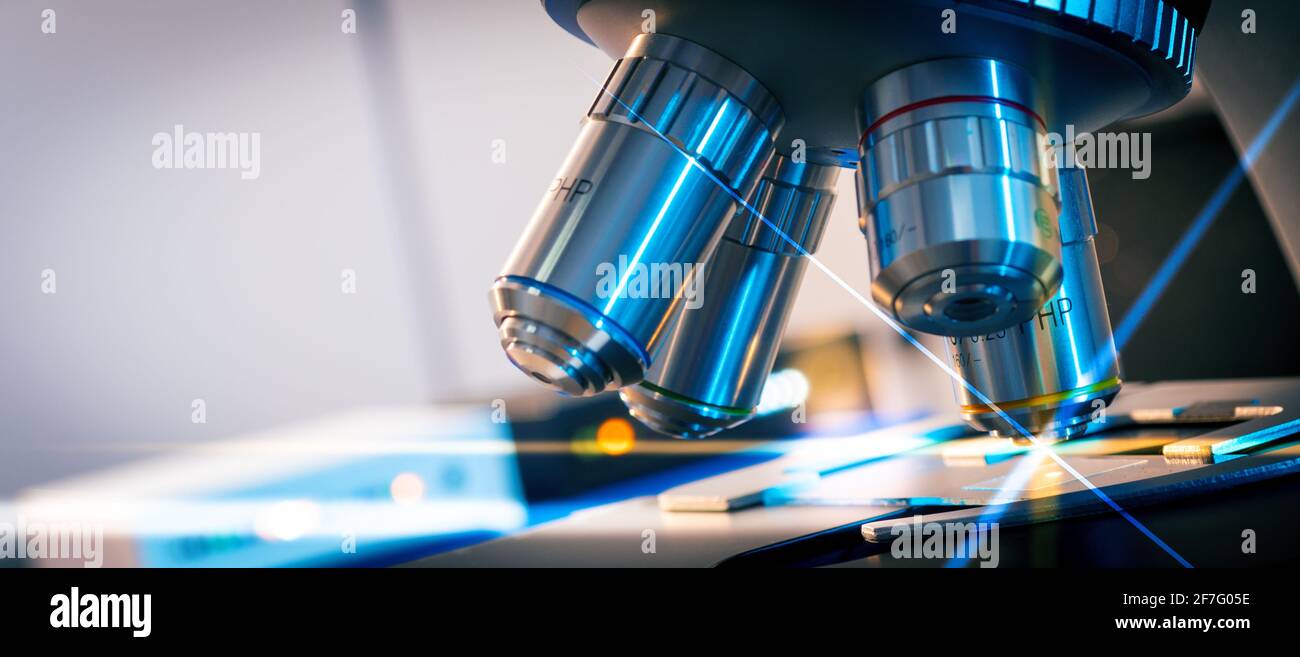 Foto en tonos de una lente de microscopio retroiluminada en una ciencia laboratorio Foto de stock