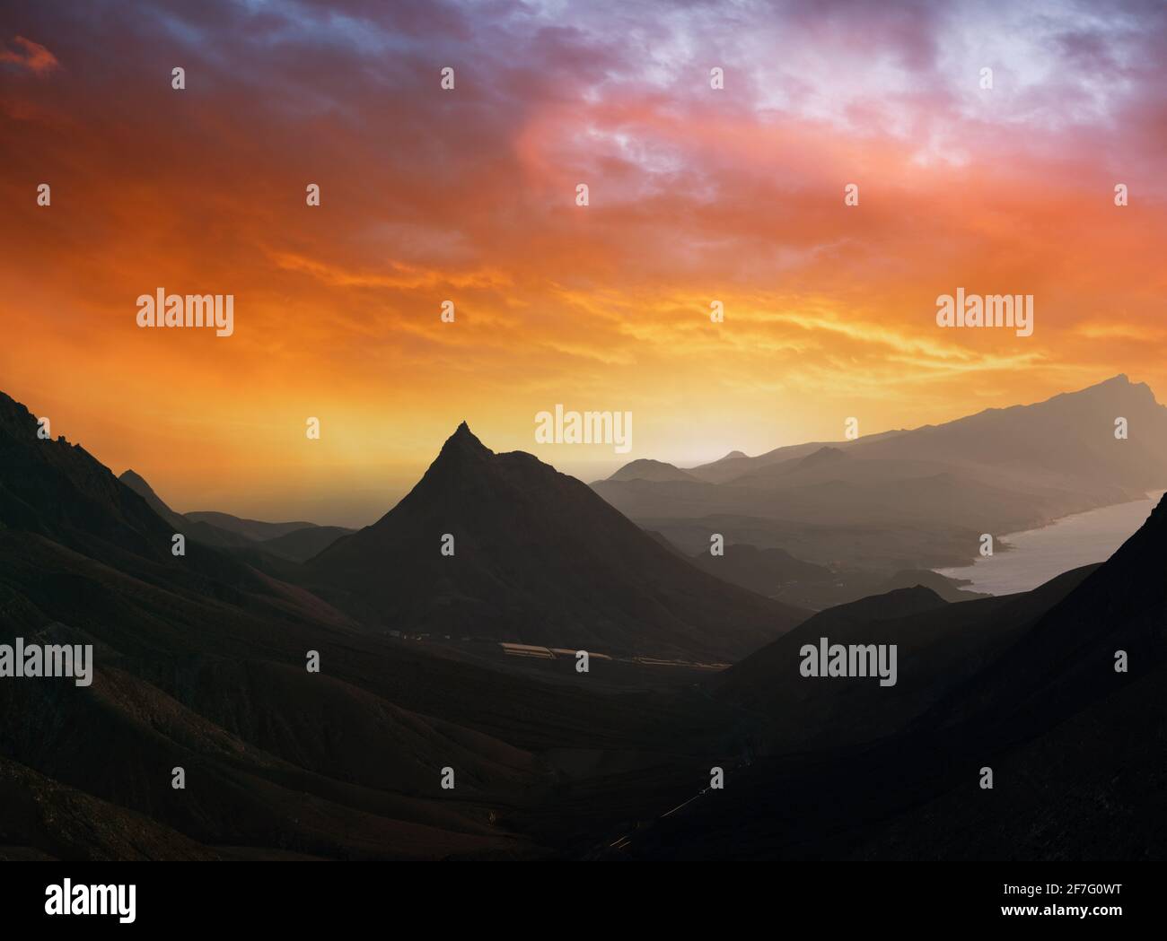 Paisaje de montaña con cielo naranja. Durante la puesta de sol Foto de stock