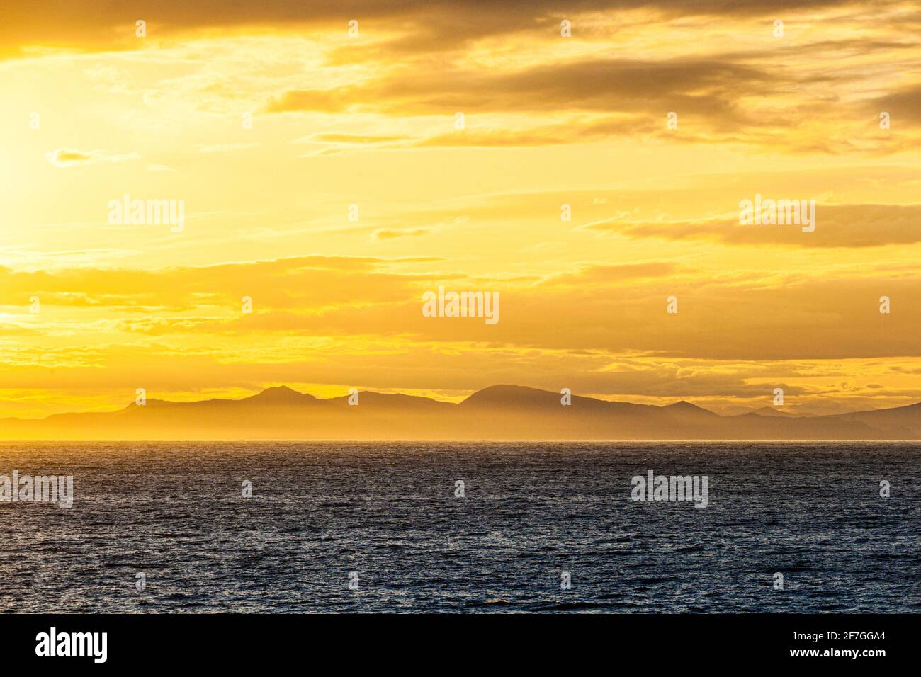 Una puesta de sol sobre la costa del Pacífico Noroeste, cerca de la Isla del Príncipe de Gales, Alaska, EE.UU. - Vista desde un crucero que navegaba el pasaje interior Foto de stock