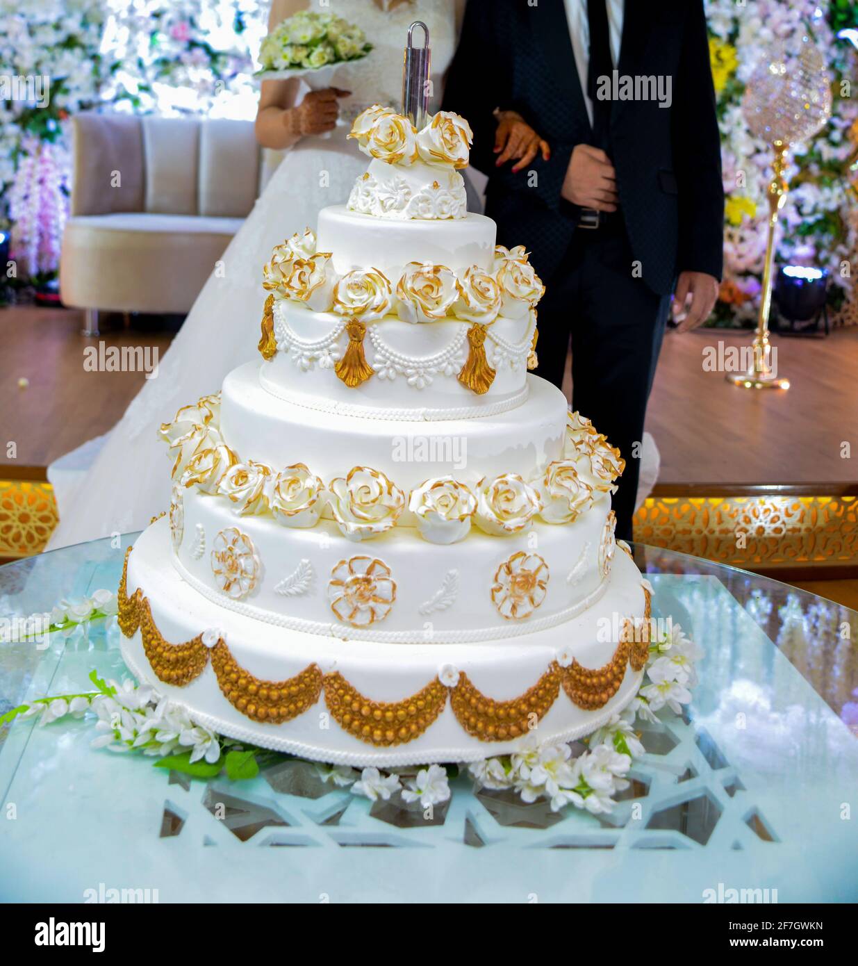 Pastel de boda blanco sobre una mesa de cristal con un telón de fondo para  los novios. Una foto del organizador de la fiesta Fotografía de stock -  Alamy