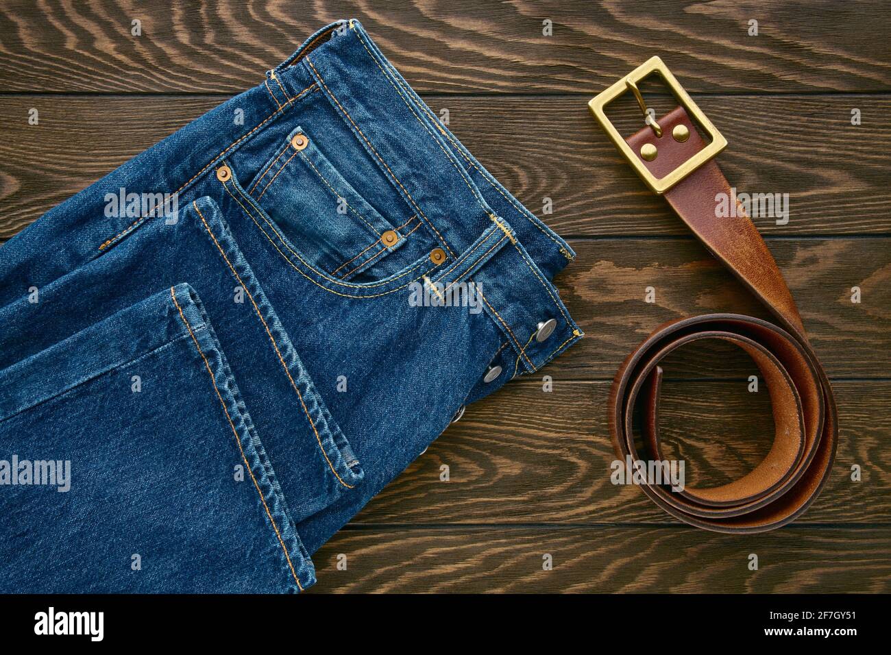 Detalle de jeans azules para hombre y cinturón de piel en madera  antecedentes Fotografía de stock - Alamy