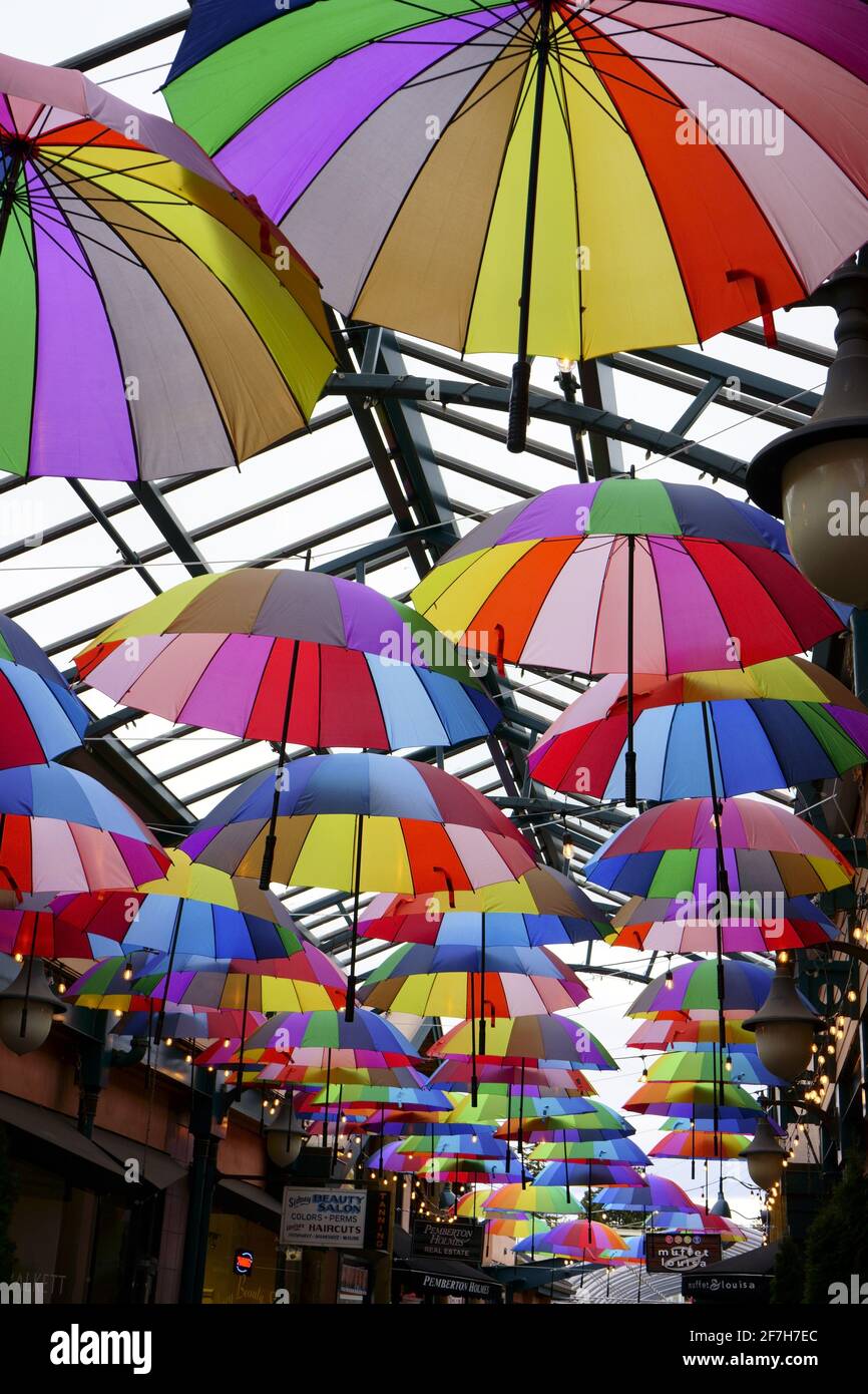 Sombrillas luminosas en un centro comercial cubierto con luz del cielo Foto de stock