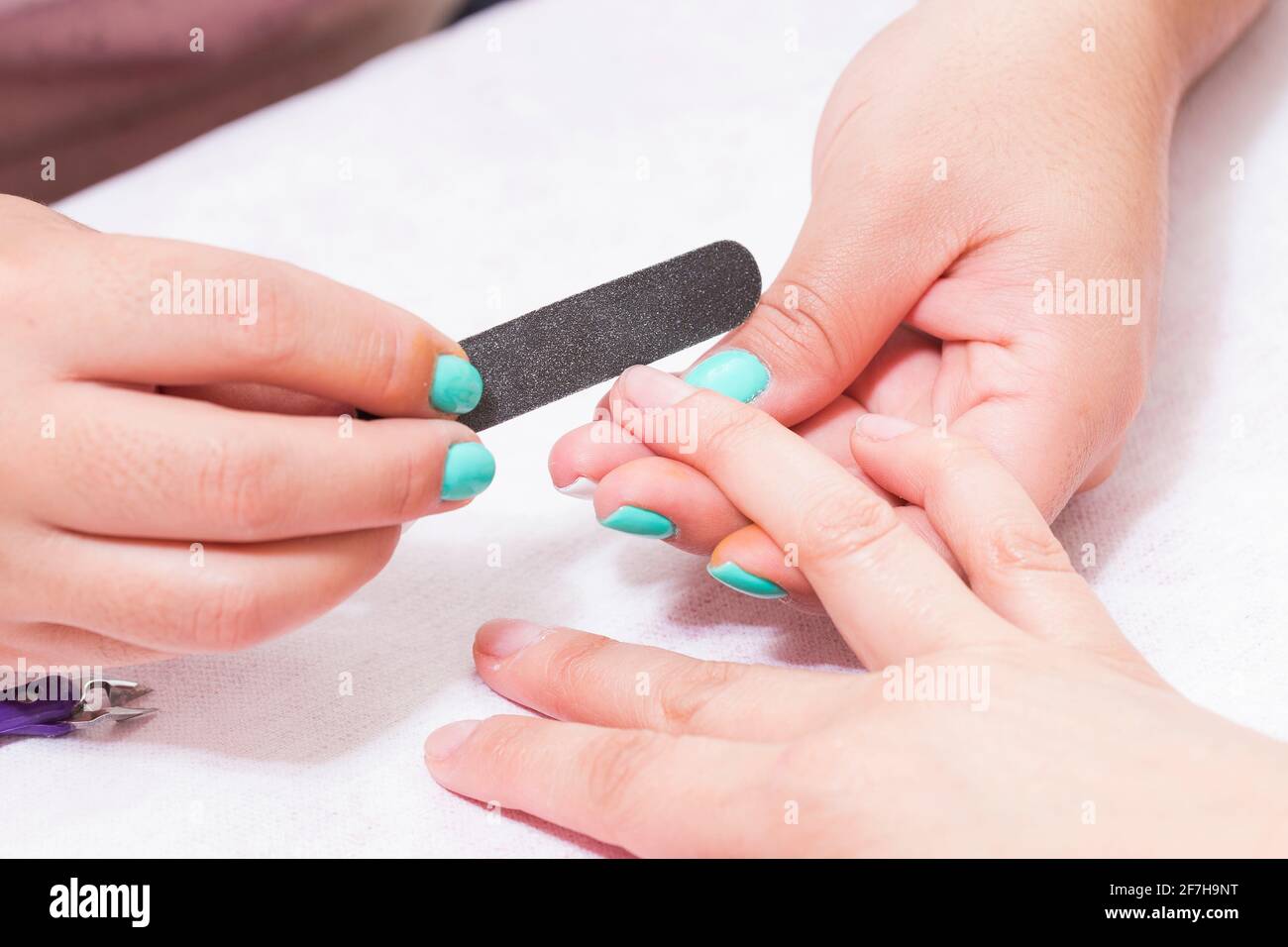 Closeup shot de una mujer en un salón de uñas reciben una manicura por una esteticista con lima de uñas. Mujer obteniendo Uña Manicura. Esteticista uñas de archivo a C Foto de stock