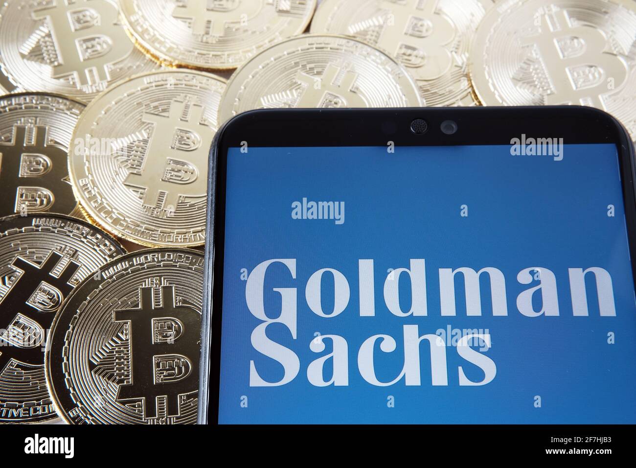 Logotipo de Goldman Sachs visto en el smartphone que se coloca en las monedas de Bitcoin. Concepto. Stafford, Reino Unido, 7 de abril de 2021. Foto de stock