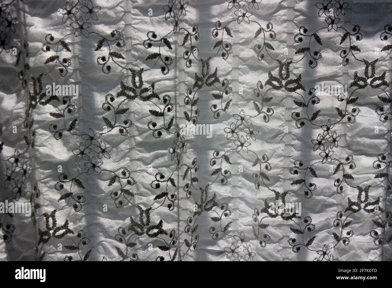 Bordado de tulle con retroiluminación natural y cortina de tela de crepe blanca en primer plano imagen de fotograma completo. Foto de stock