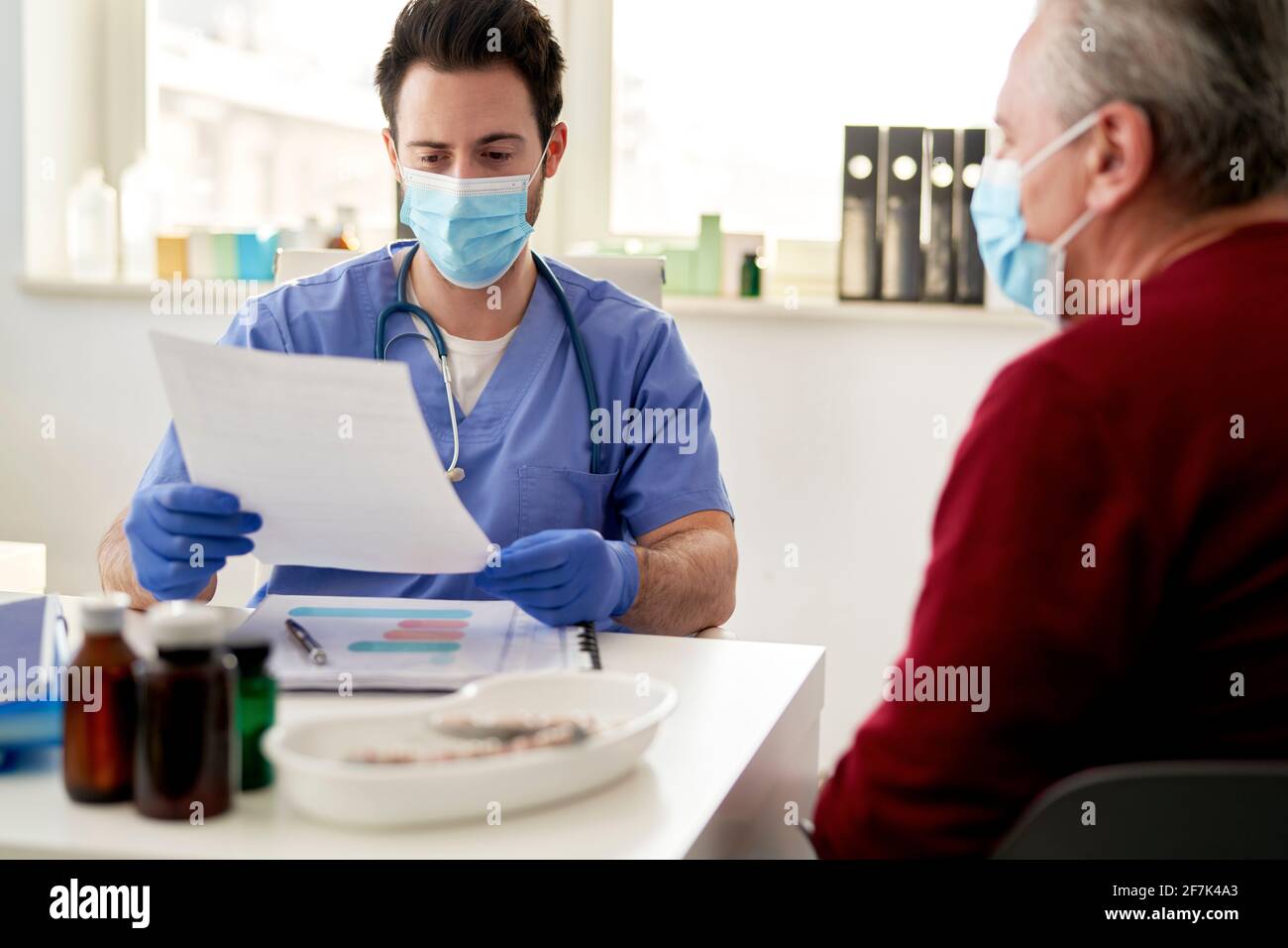 El médico revisa los resultados del paciente mayor Foto de stock