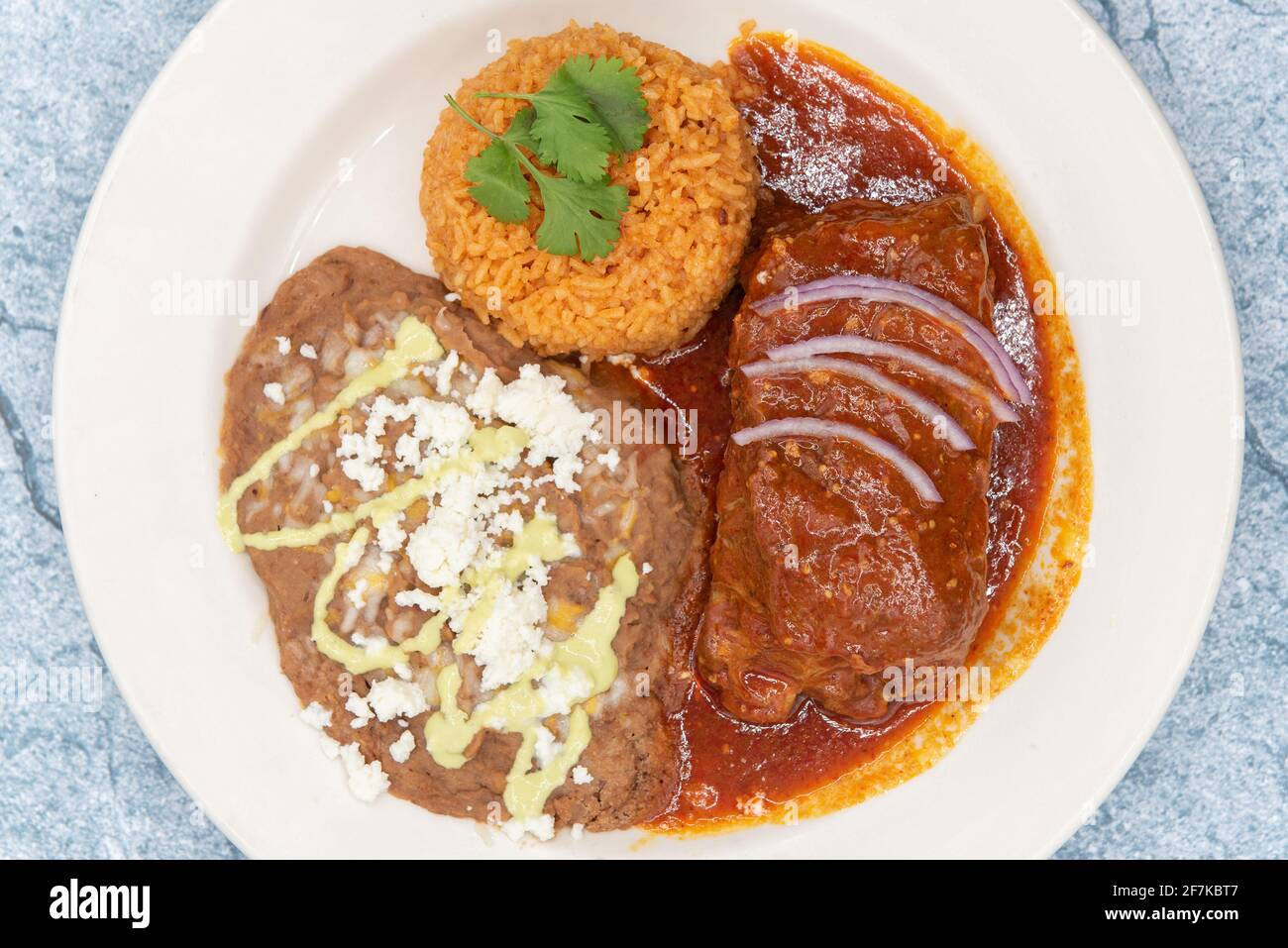 Vista aérea de la gran bofetada de Chile Colorado carne de entrada, frijoles refritos, y arroz empapado en la salsa roja. Foto de stock