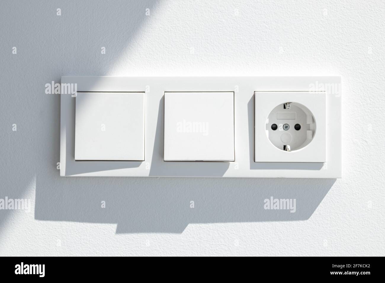 Moderna placa de interruptores blanca con dos interruptores y un conector  macho europeo. Toma eléctrica europea Fotografía de stock - Alamy