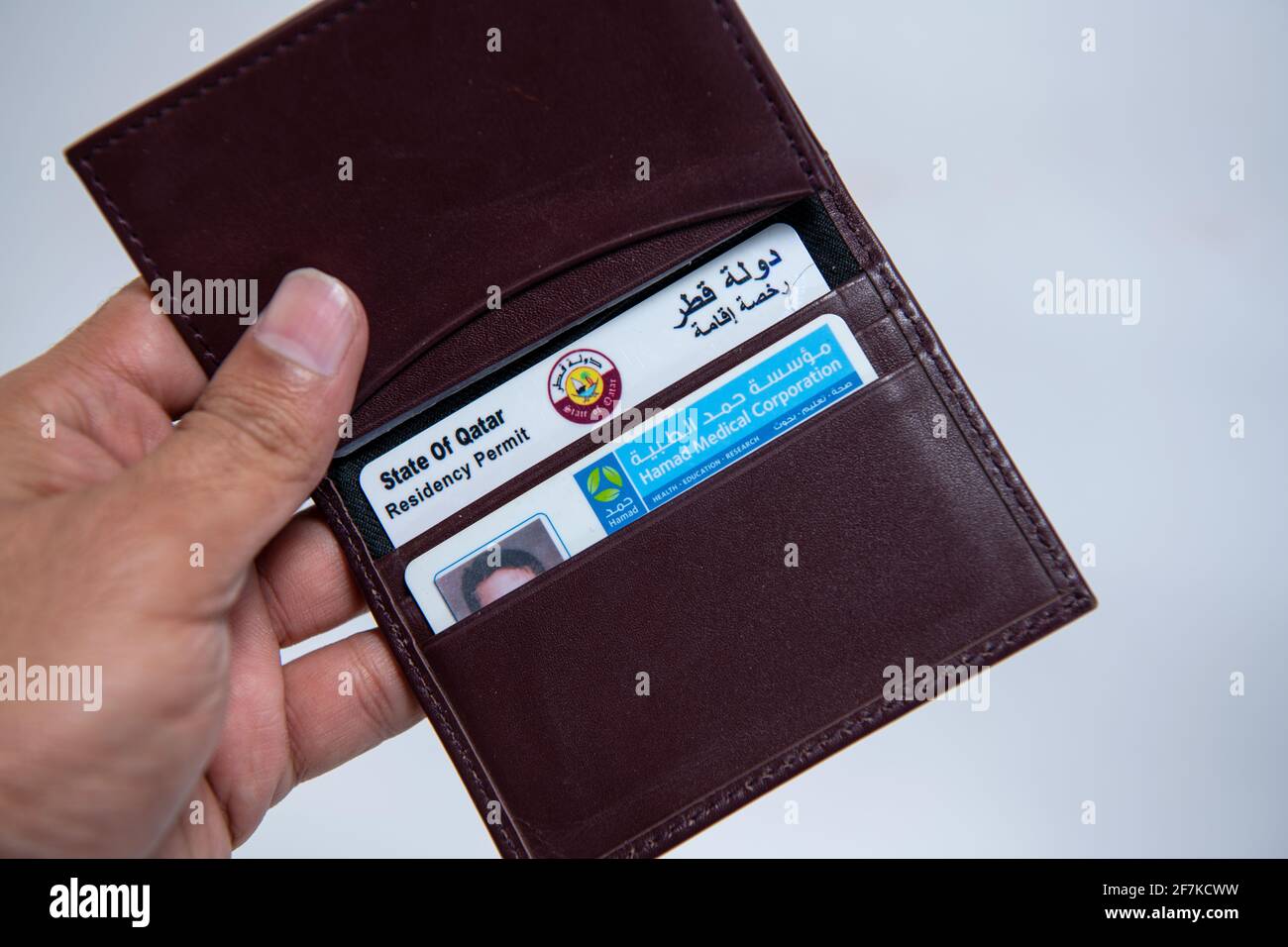 Tarjeta de identificación de Qatari y Health Hard in Leather Valet encendido Fondo aislado Foto de stock