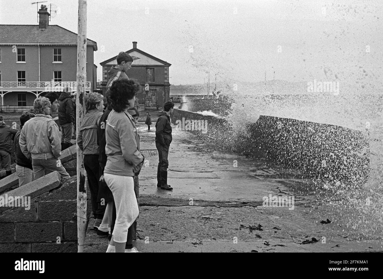 Gente, olas rompiendo en el paseo marítimo después de una tormenta pesada, 26 de agosto de 1986, Bray, Condado de Wicklow, Irlanda Foto de stock