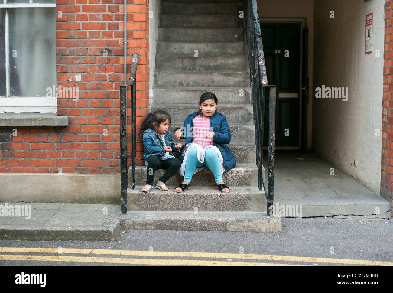 Retrato ambiental de niños musulmanes jugando fuera de su casa. Municipio cerca de Boundary Gardens, Shoreditch, Hackney, Londres, Reino Unido. Jul 2015 Foto de stock