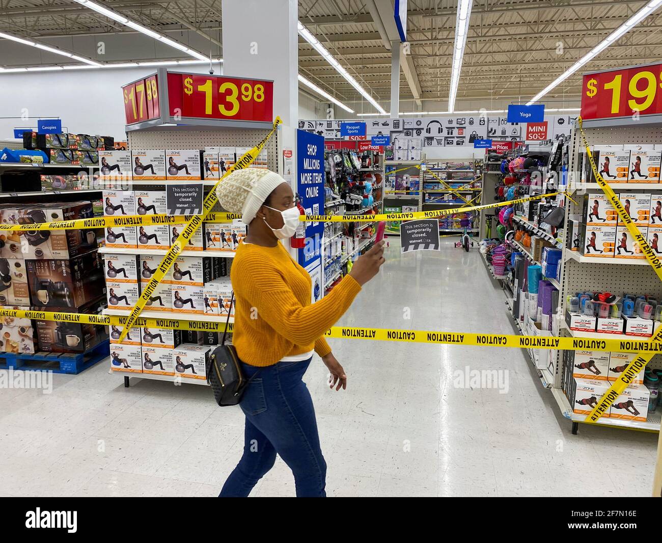 Una mujer pasa por delante de los pasillos de artículos no esenciales en  una tienda Walmart, ya que se imponen nuevas medidas a las grandes tiendas  debido a la pandemia de la