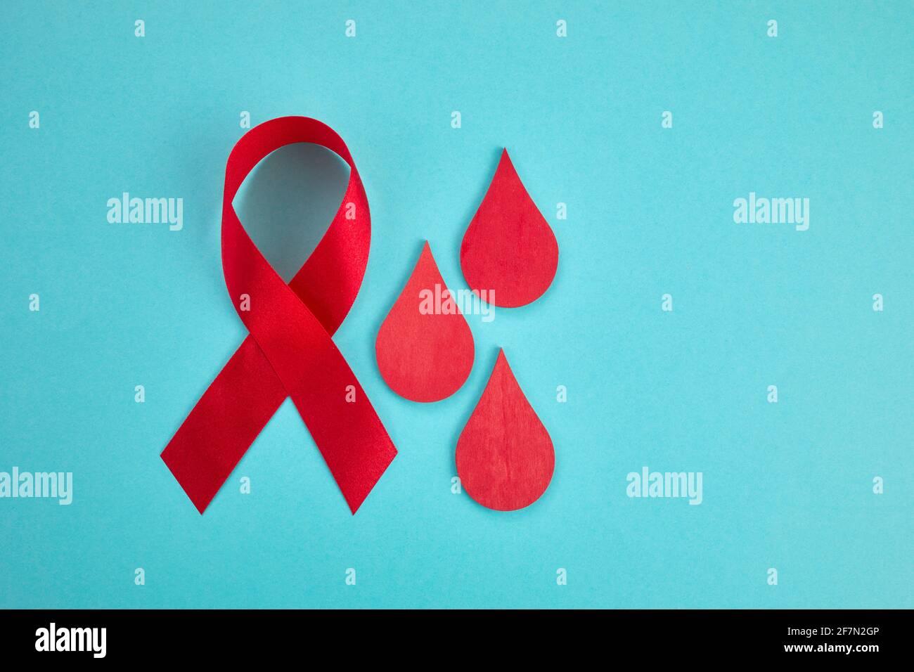 Conciencia oncept con gota de sangre y cinta roja. Día Mundial de la Hamofilia o día de donantes de sangre. Foto de stock