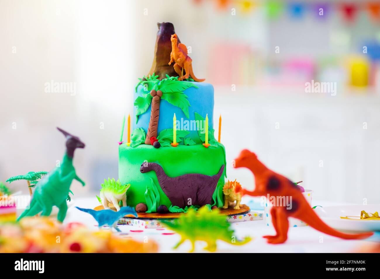 Fiesta de cumpleaños de los niños. Pastel de dinosaurio tema. Niña soplando  velas y abriendo regalos. Evento para niños. Decoración para la celebración  temática de los dinosaurios Fotografía de stock - Alamy