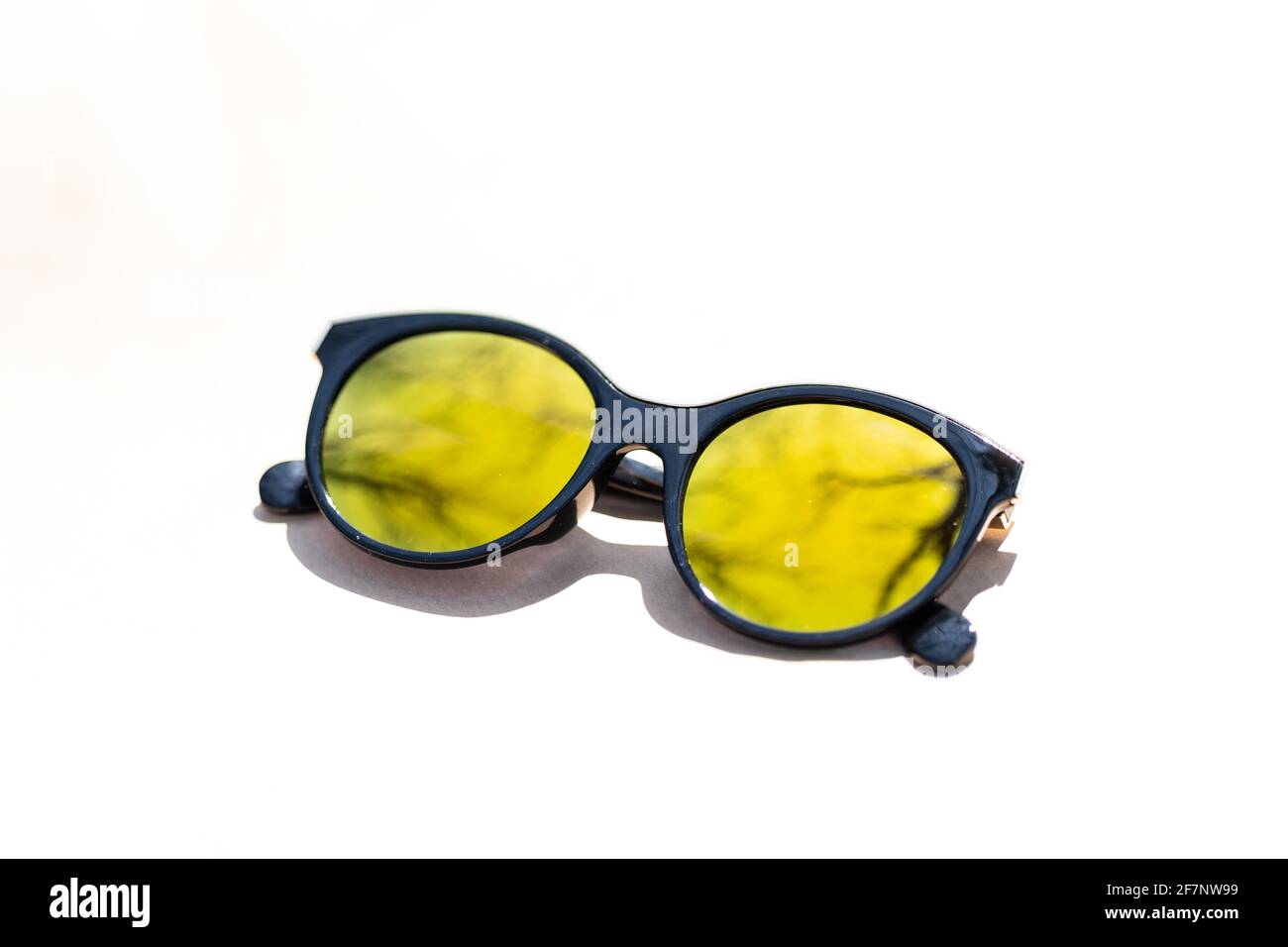 Gafas de sol de ojos de gato de moda para mujeres con lentes grandes redondas  amarillas y marco negro disparar fuera en un día soleado de primer plano.  Enfoque selectivo Fotografía de