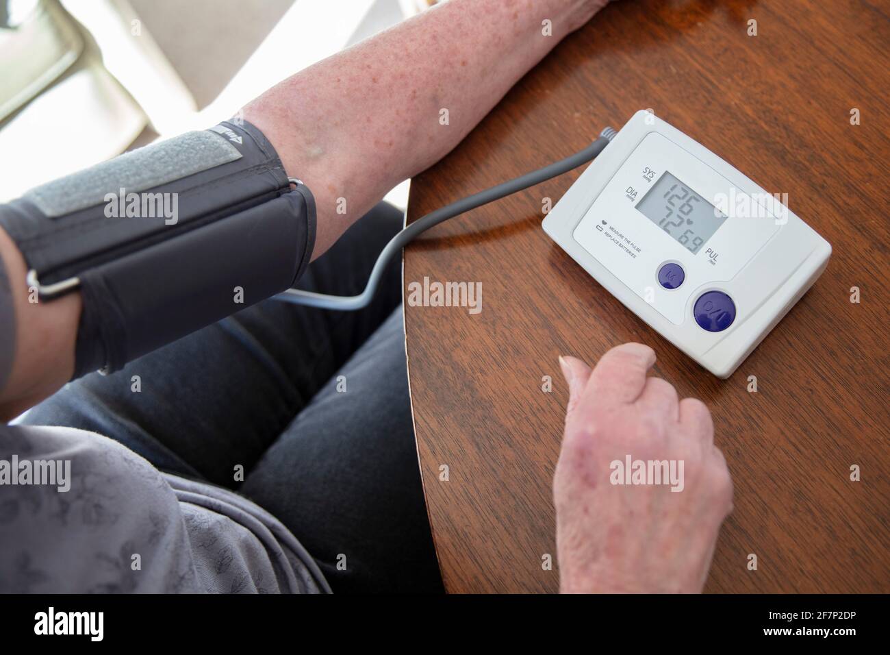 Una mujer mayor controla su presión arterial en casa. Concepto de atención de salud Foto de stock