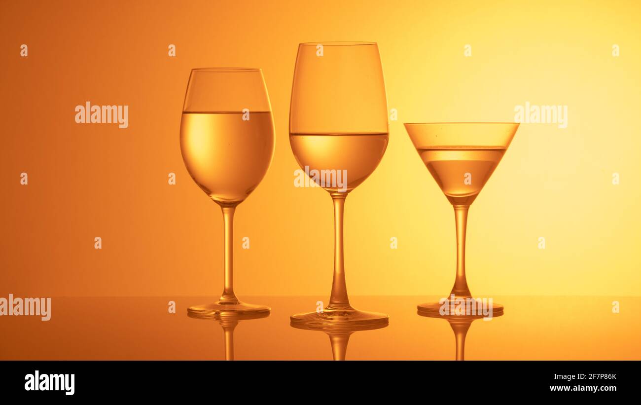Copas de vino de cristal sobre un fondo de color Foto de stock