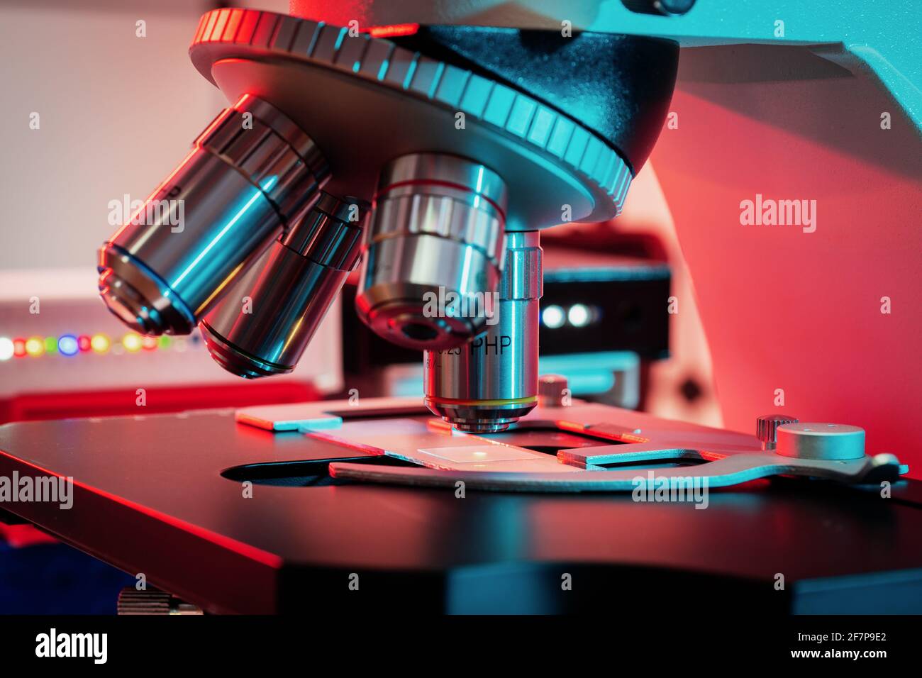 Foto en tonos de una lente de microscopio retroiluminada en una ciencia laboratorio Foto de stock