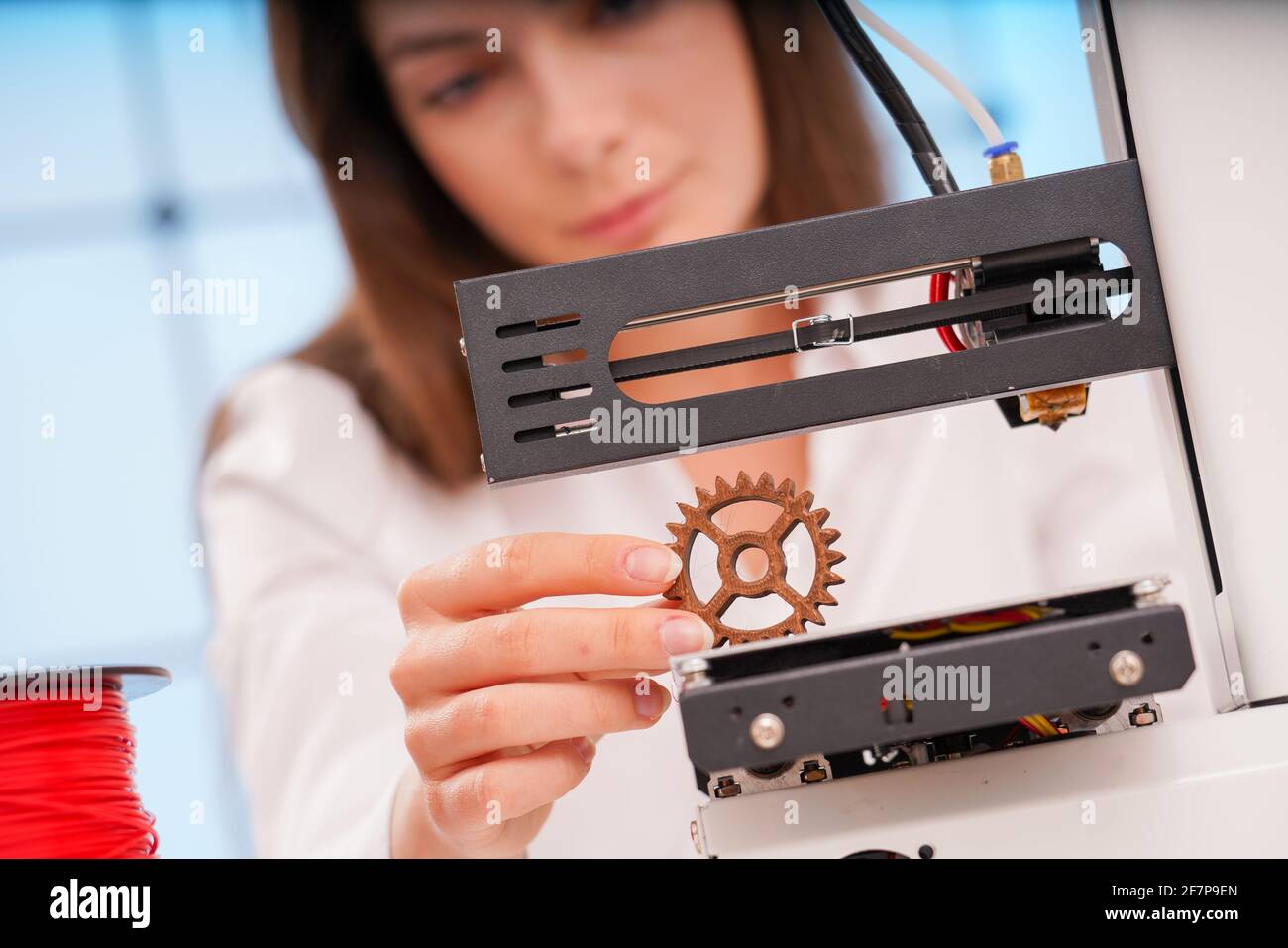 Joven diseñadora trabajando en un dispositivo prototipo en una impresora 3D Foto de stock