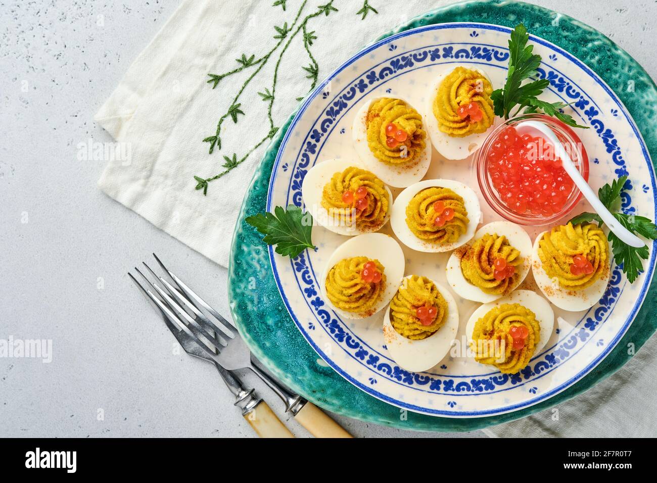 Huevos rellenos con caviar rojo y pimentón en el plato para aperitivo mesa  de pascua, vista superior, espacio para copias. Plato tradicional para las  felices fiestas de Pascua Fotografía de stock 