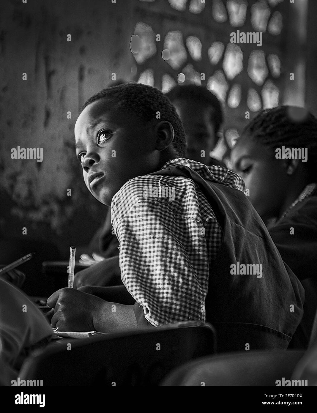 Joven estudiante de Malawi que se concentra duro en el aula, mirando a la pizarra Foto de stock