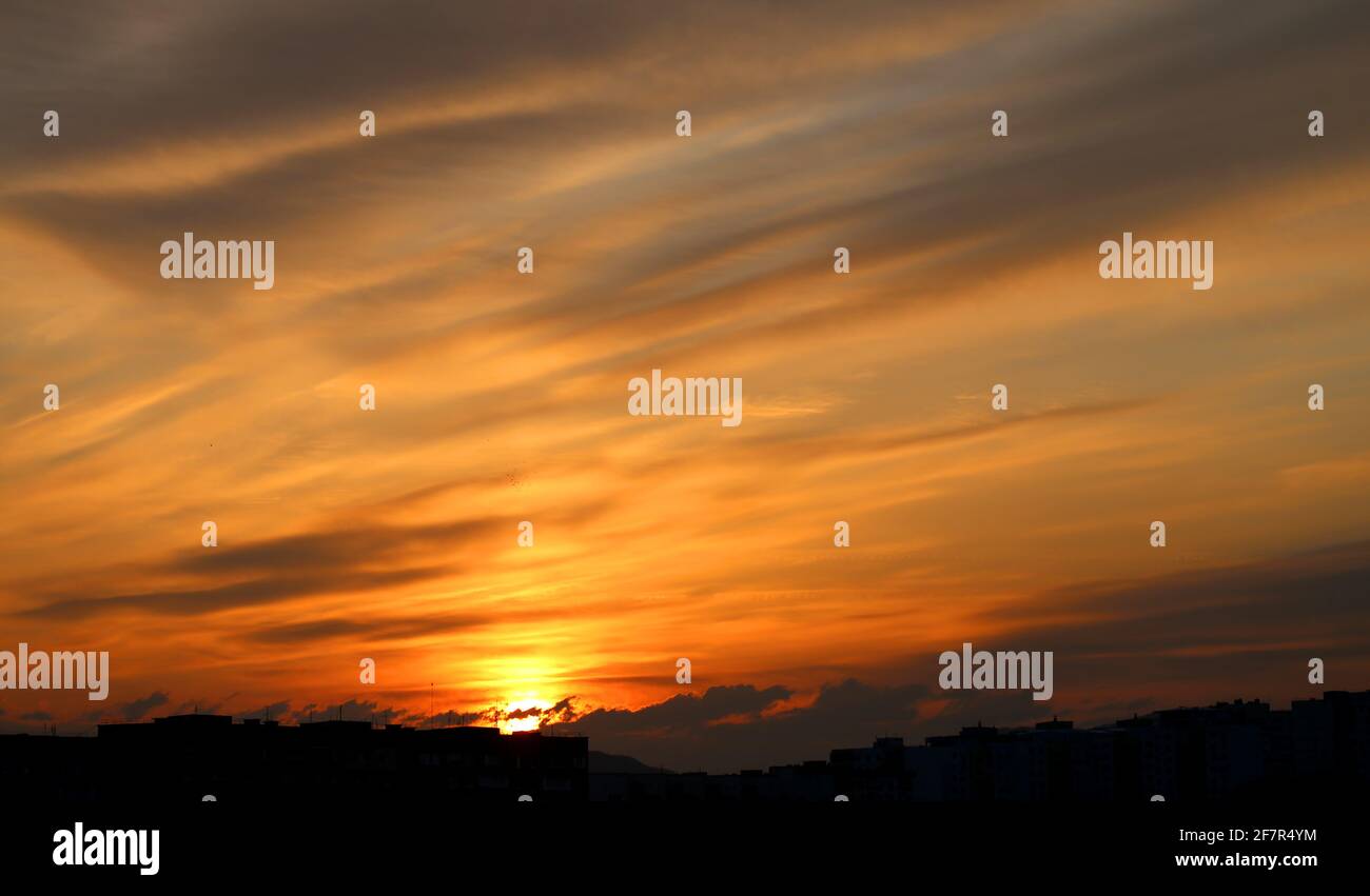 Foto fondo noche de una hermosa puesta de sol con las nubes encima la ciudad Foto de stock