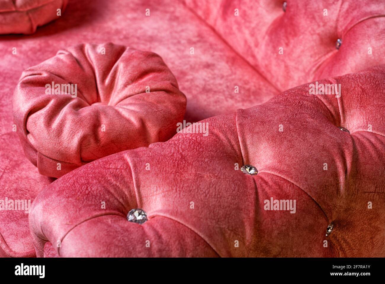 sofá suave rojo con grandes piedras de rinoceronte de cerca Foto de stock