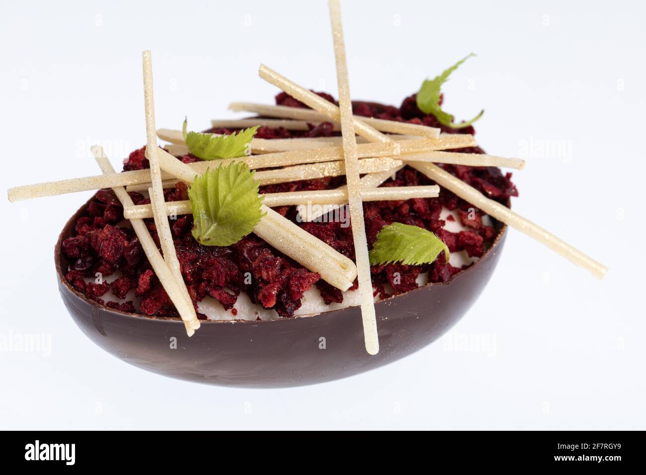 Postre de huevo de chocolate con mousse de fruta de la pasión decorada con arándanos picados aislados sobre blanco Foto de stock